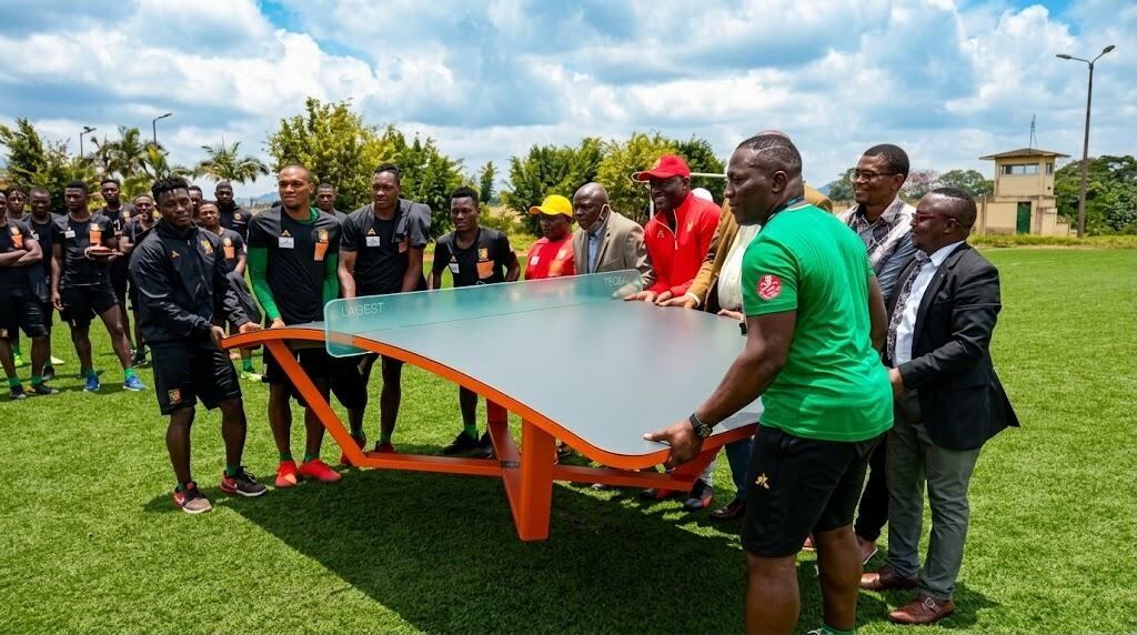 Joueurs et officiels autour d'une table de teqball sur un terrain en herbe